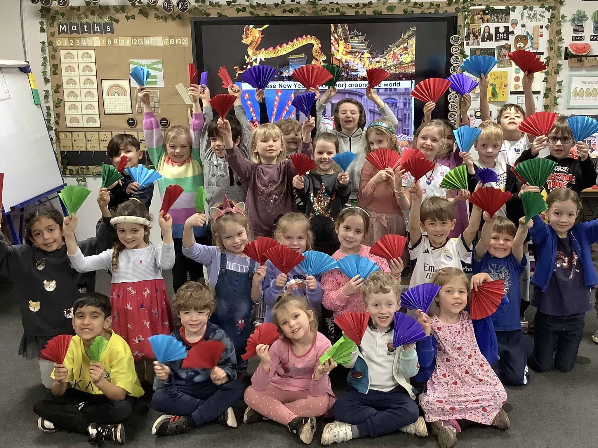 Pupils holding fans and decoration for Chinese New Year.