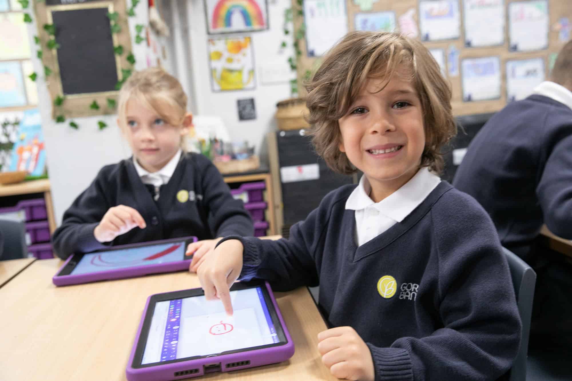 Pupils at Gorsey Bank work on iPads and smile during class.