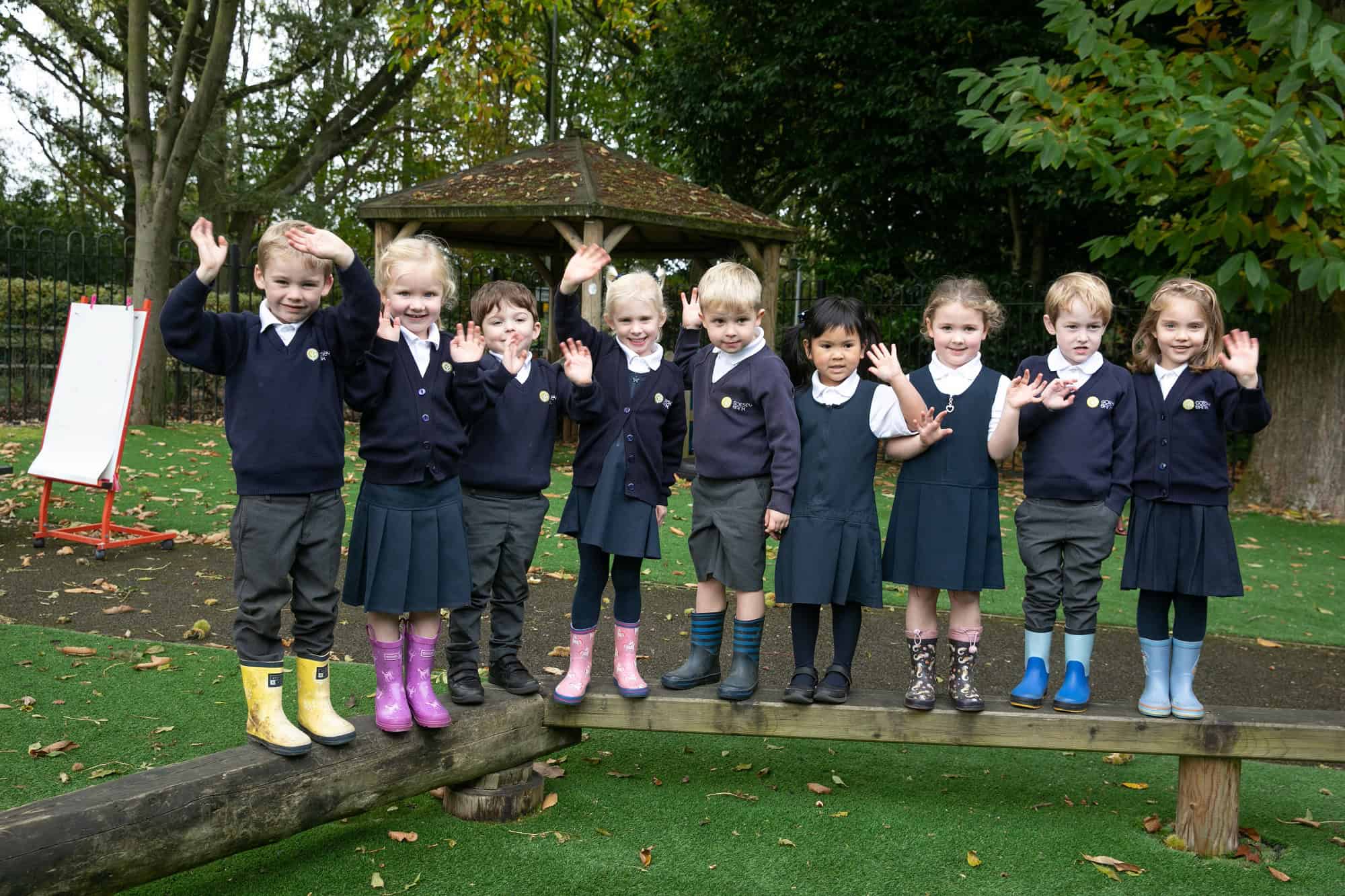 A group of pupils at Gorsey Bank stand outside waving